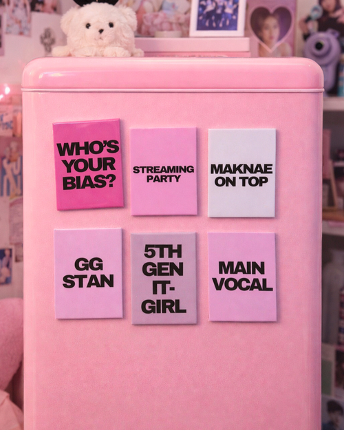 Pink refrigerator with colorful K-POP magnets on a blurred background