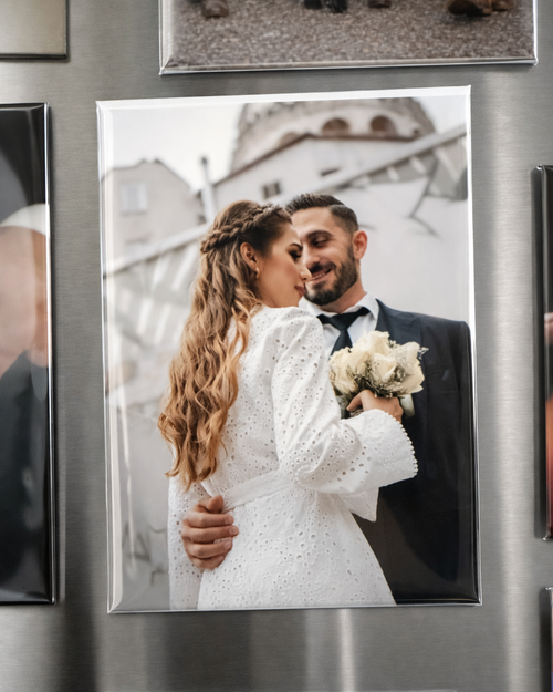 Fridge with a magnet of a bride and groom embracing, surrounded by other photos.